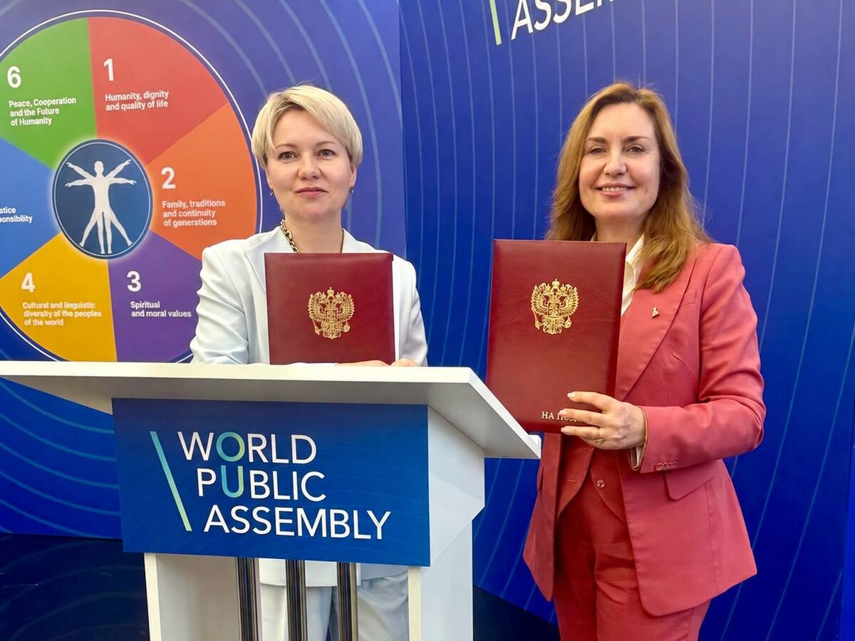 Наталья Жирнова (слева) с дипломом у трибуны World Public Assembly